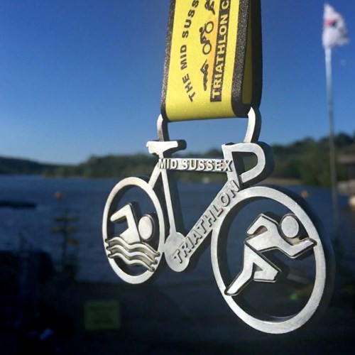 the mid Sussex Triathlon medal for 2019, in the shape of a bicycle.